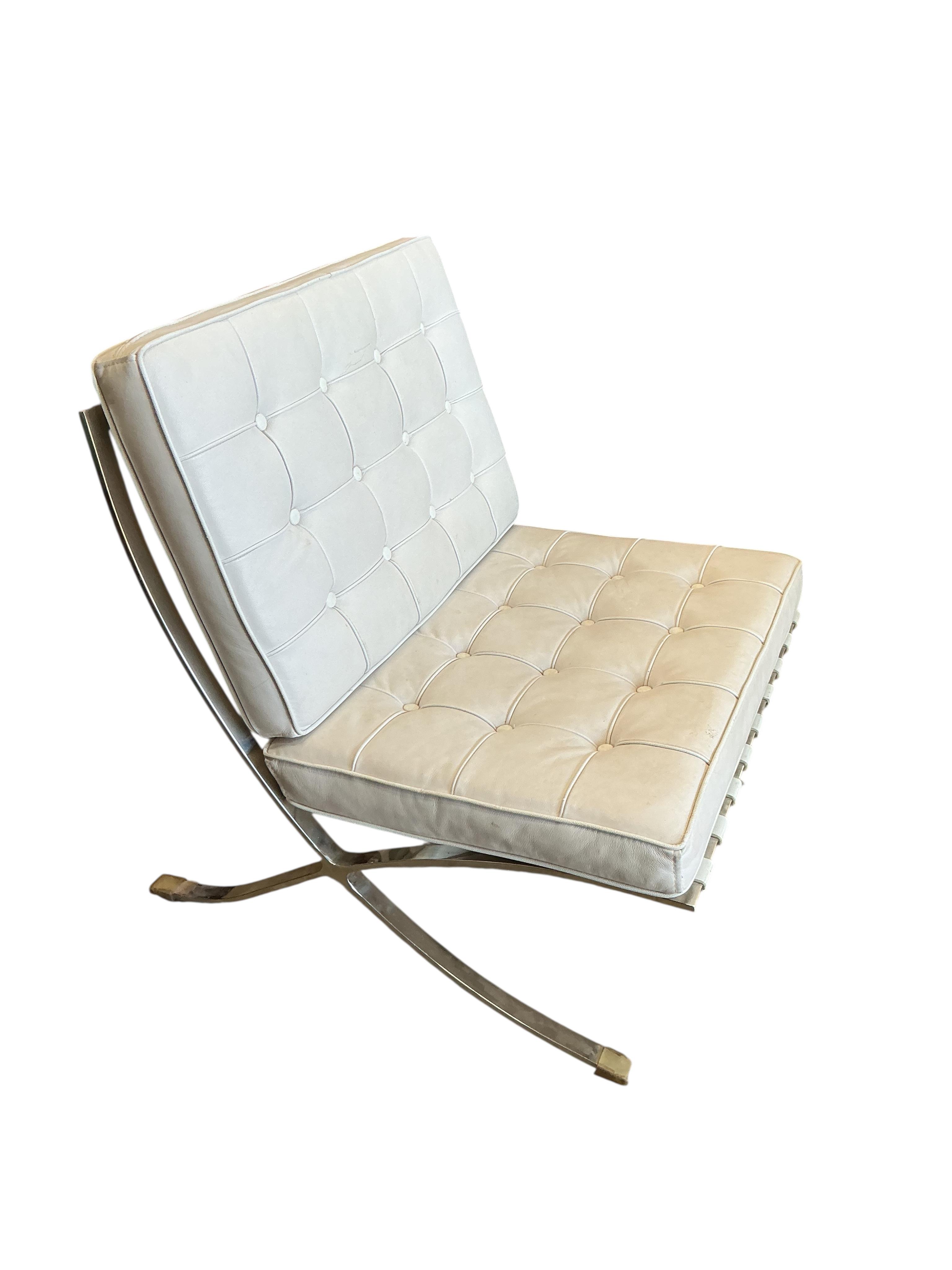 A pair of 'Barcelona' style white leather chairs, width 78cm, depth 80cm, height 82cm and a footstool